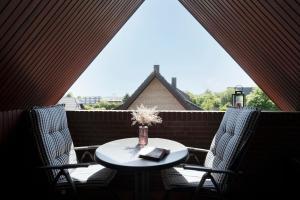 a table and chairs with a vase of flowers on a balcony at Hasenkamp 18 Krabbe in Grömitz +18 photos