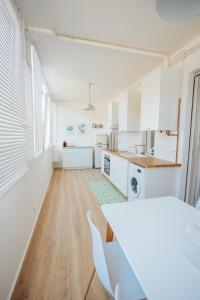 Una cocina con gabinetes blancos y una mesa y sillas. en Dimora Vittoria Apartment, en Montesilvano