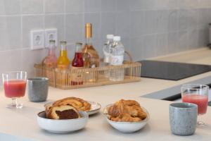 a kitchen counter with two bowls of pastries and drinks at 2bd Luxury Sea View Penthouse In Astir Beach in Athens +11 photos