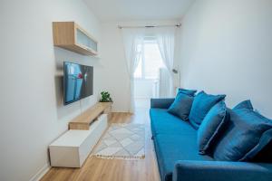 a living room with a blue couch and a tv at Dimora Vittoria Apartment in Montesilvano