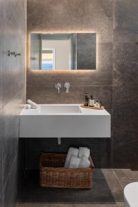 a bathroom with a white sink and a mirror at 2bd Luxury Sea View Penthouse In Astir Beach in Athens