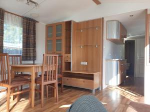 a kitchen with wooden cabinets and a table and chairs at Camping Pré Vologne in Granges-sur-Vologne +32 photos