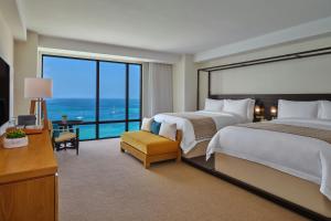 a hotel room with two beds and a large window at The St. Regis Aruba Resort in Palm-Eagle Beach +92 photos