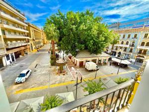 a city street with a white car and a tree at Apartamento centro 1A in Huelva