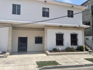 a white building with black barred windows at DGMLoftsTEC comodo zona sur MTY in Monterrey