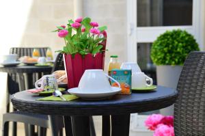 einen Tisch mit einem Teller Essen und Blumen darauf in der Unterkunft B&B San Domenico in Modugno