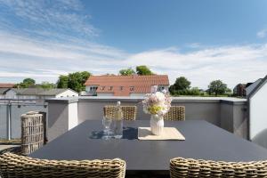 a table with chairs and a vase of flowers on a balcony at Ostseedomizil Beachloft in Kellenhusen +21 photos