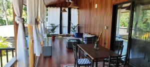 a living room with a table and chairs on a porch at Pinocchio Cosy house in Puerto Viejo