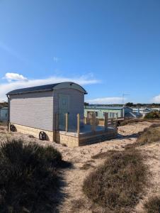 a small shack on a beach with the water at Modern Eco-Lodges near Findhorn Beach in Findhorn +43 photos