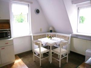 Benshausen的住宿－Karin's behagliche Ferienwohnung，厨房配有桌椅和2扇窗户。