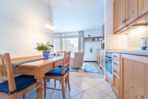 a kitchen with a wooden table and chairs at Hamburger Straße 3- Wohnung 5 in Grömitz