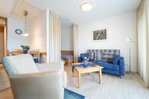 a living room with a blue couch and a table at Hamburger Straße 3- Wohnung 5 in Grömitz