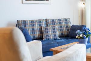 a blue couch with pillows in a living room at Hamburger Straße 3- Wohnung 5 in Grömitz
