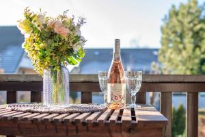 a bottle of wine and two glasses on a table at Hamburger Straße 3- Wohnung 5 in Grömitz +17 photos
