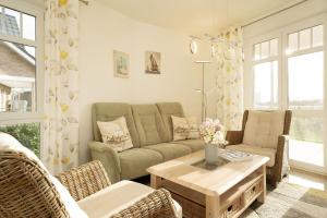 un salon avec un canapé, des chaises et une table dans l'établissement Bürgermeister-Fox 42a Meer-Blick, à Neue Tiefe Fehmarn