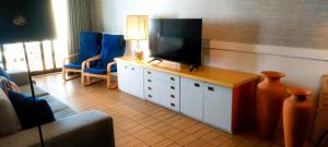 a living room with a flat screen tv and blue chairs at Casa Foz do Rio in Caminha +14 photos