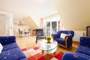 a living room with blue chairs and a table at Wohnung 4 in Schönberger Strand