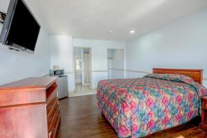 a bedroom with a bed and a flat screen tv at Day & Night Inn in Hesperia