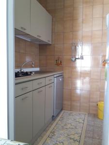 a kitchen with white cabinets and a sink at Alba Apartment in Laigueglia