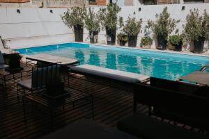 a swimming pool with tables and chairs and plants at Premium Tower Suites Mendoza in Mendoza