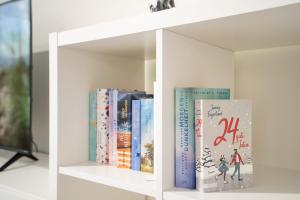 ein weißes Bücherregal mit Büchern drauf in der Unterkunft Pier 67 Familienkoje Marina Neustadt in Roge + 35 Fotos