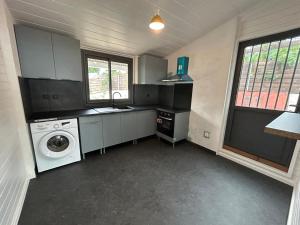 a kitchen with a washing machine and a washer at La Kaz Bon'R in Étang-Salé