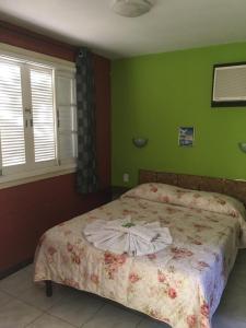 a bed in a bedroom with green walls at City Park Hotel in Penedo