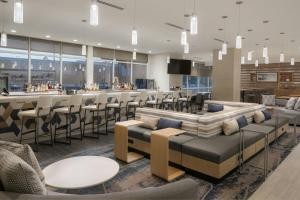 a restaurant with a bar with stools and tables at SpringHill Suites by Marriott Tampa Downtown in Tampa