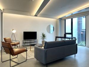 a living room with a couch and chairs and a television at Lesplanade By Wynwood House in Panama City
