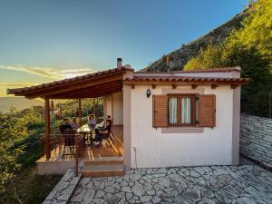 a house with people sitting at a table on a deck at SunView Villa in Kostar