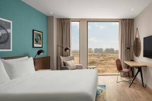 una camera d'albergo con un letto bianco e una scrivania di Four Points by Sheraton Dakar Diamniadio a Dakar
