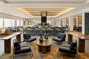 un vestíbulo con sillas y una mesa con flores. en Oshkosh Marriott Waterfront Hotel & Convention Center, en Oshkosh