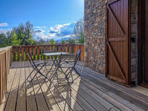a patio with a table and chairs on a deck at Ca la Rosa 2 in Llivia +3 photos