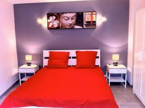 ein Schlafzimmer mit einem roten Bett mit zwei Nachttischen in der Unterkunft Le Relais in Lavoûte-Chilhac