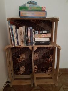 a book shelf with a pile of books at Kasa Sirena in Tarrafal
