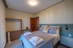 a bedroom with a bed with two towels on it at Casa Pé no Lago - Descanso em Família na Praia de Barra Grande! in Barra Grande +17 photos