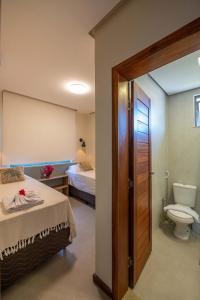a bathroom with a bed and a toilet in a room at Casa Pé no Lago - Descanso em Família na Praia de Barra Grande! in Barra Grande