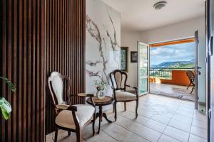 a living room with chairs and a table and a balcony at Apartments Radević in Budva