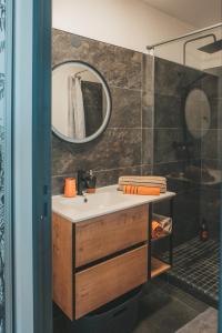 une salle de bain avec un lavabo et un miroir dans l'établissement Le point de vue Studio saint Denis, à Saint-Denis 24 autres photos
