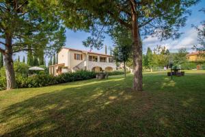 a house in a park with trees in the grass at Casa Vacanze Poggio Aprico in Venturina Terme