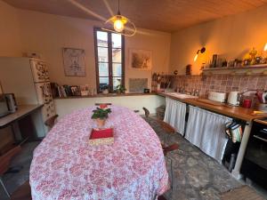 a kitchen with a table with a pink table cloth at La Chambre Rose-Maison Searle à Tourtour in Tourtour