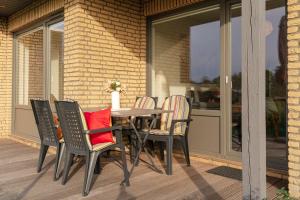 a table and chairs on a patio with a window at Blankwasserweg 131 Lensterstrand Oase Bungalow 7 in Lenste