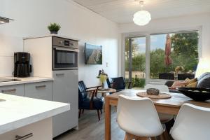 a kitchen and dining room with a table and chairs at Blankwasserweg 131 Lensterstrand Oase Bungalow 7 in Lenste +33 photos