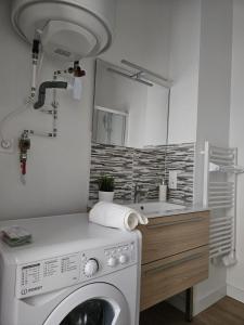a bathroom with a washing machine and a sink at West Side Story - Wifi ,City center in Beaupréau