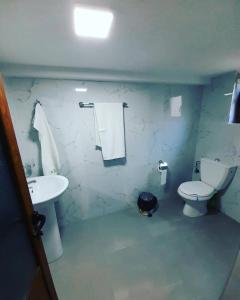a bathroom with a white toilet and a sink at Pogradec Lake Apartments in Pogradec +6 photos