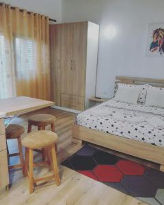 a bedroom with a bed and a table and two stools at Pogradec Lake Apartments in Pogradec