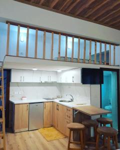 a kitchen with a sink and a counter with stools at Pogradec Lake Apartments in Pogradec