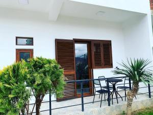 a balcony with chairs and a table and a window at Pogradec Lake Apartments in Pogradec
