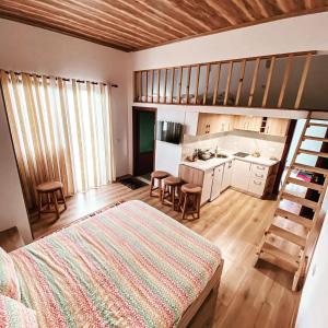 a bedroom with a bed and a kitchen with a ladder at Pogradec Lake Apartments in Pogradec