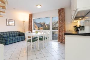 a kitchen and living room with a table and chairs at Seepferdchen Freetied in Sierksdorf